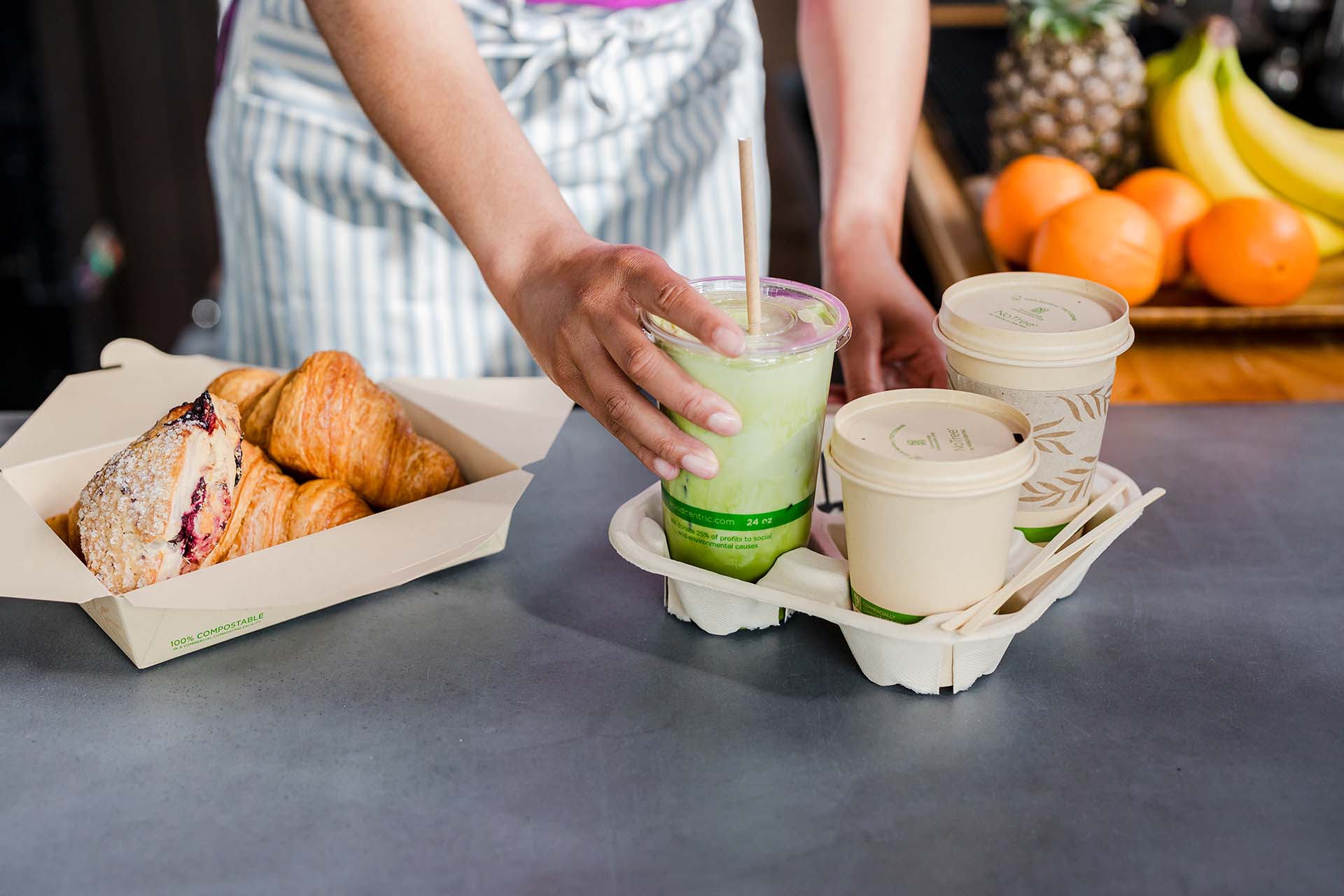 A server places compostable cups into a drink holder tray